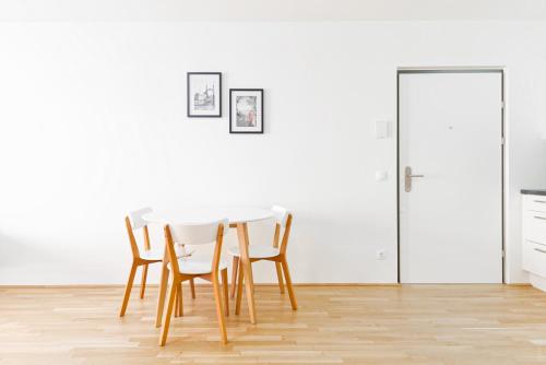 einen Esstisch und Stühle in einem weißen Raum in der Unterkunft Whats-App Self-Check-IN - 1BR Apartment, near airport,15 min to Center in Wien