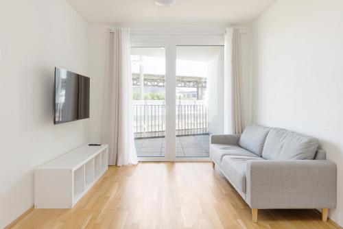 ein Wohnzimmer mit Couch und Fernseher in der Unterkunft Whats-App Self-Check-IN - 1BR Apartment, near airport,15 min to Center in Wien