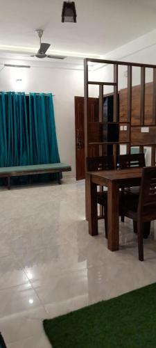 a living room with a wooden table and benches at Royal Square Service Apartment in Thrissur Town in Trichūr