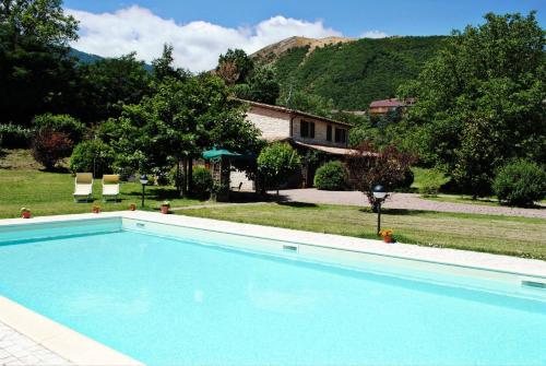 una gran piscina en un patio con una casa en Il Bosso, en Cagli