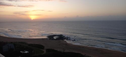 a sunset over a beach with the ocean at 146 Stella Maris Durban Amanzimtoti in Amanzimtoti