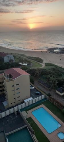 a view of the beach and the ocean at sunset at 146 Stella Maris Durban Amanzimtoti in Amanzimtoti