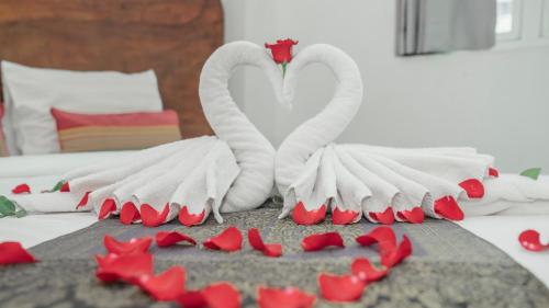 two white swans sitting on a bed with red hearts at Monsoon Bassac Hotel in Phnom Penh