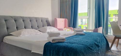 ママイア・ノルドにあるSUNSHINE PLACE ApartHotel Pool & Spa Mamaia Nordのベッドルーム1室(タオル付)