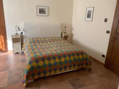 Un dormitorio con una cama con una manta de colores. en Il Bosso, en Cagli