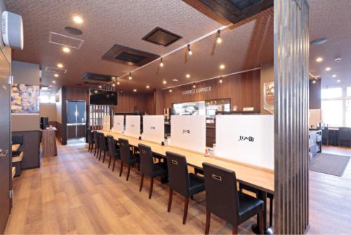 une longue table et des chaises dans un restaurant dans l'établissement A&Bee HOTEL, à Ōita