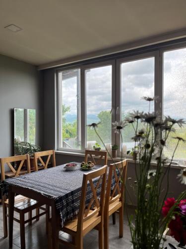 a dining room with a table and chairs and windows at Eco family guest house in Mlashe