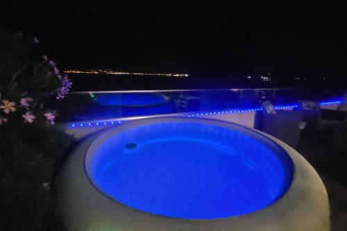 une baignoire bleue posée à côté d'une piscine la nuit dans l'établissement Appartement terrasse et vue mer, à Grosseto-Prugna