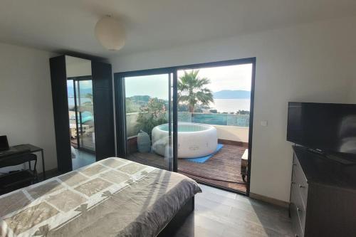 - une chambre avec une baignoire et un balcon avec une télévision dans l'établissement Appartement terrasse et vue mer, à Grosseto-Prugna