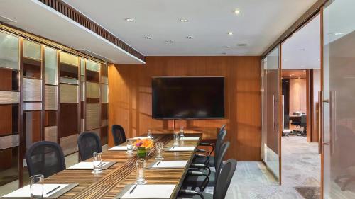a conference room with a long table and a flat screen tv at Marco Polo Parkside, Beijing in Beijing