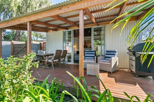 a deck with a pergola and a table and chairs at Coral Haven - Aldinga Beach - C21 SouthCoast Holidays in Aldinga Beach