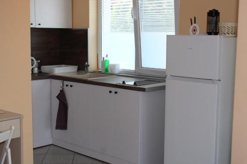 a kitchen with a white refrigerator and a window at Къща за гости Света Марина in Krapets