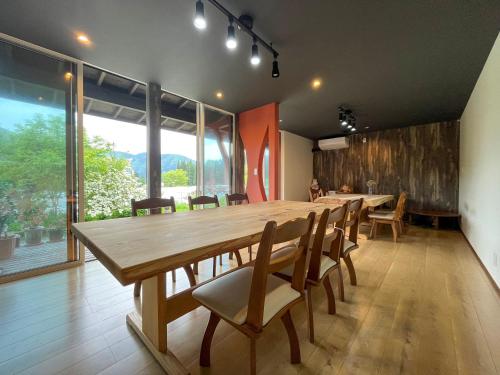 uma sala de jantar com uma grande mesa de madeira e cadeiras em noukanoyado seisetsukan em Senboku