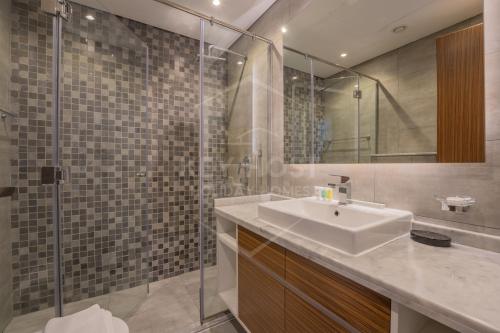 a bathroom with a sink and a glass shower at KeyHost - Regent Court JVC - K180 in Dubai