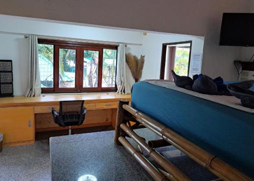 a bedroom with a bed and a desk and window at Sense Asia in Haad Tian
