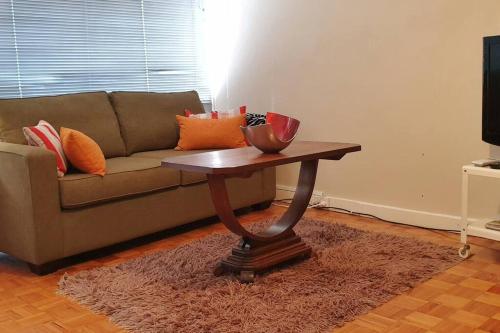 a living room with a couch and a coffee table at Elwood Beach Apartment (2 min walk from beach) in Melbourne