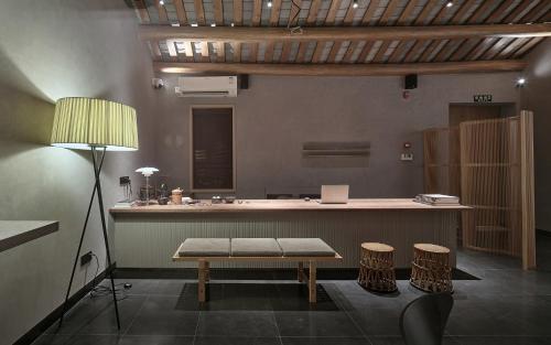 a room with a counter with a bench and two stools at Jiangnan House Chaozhou in Chaozhou
