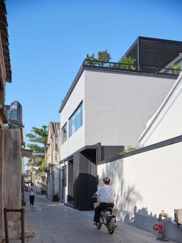 a person riding a bike down a street at Jiangnan House Chaozhou in Chaozhou