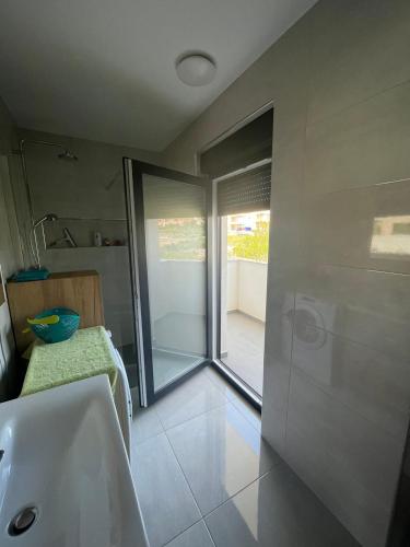 a bathroom with a tub and a sink and a window at Apartman Mara Vodice in Vodice