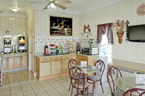 a kitchen with a table and chairs and a dining room at Rodeway Inn in Canton