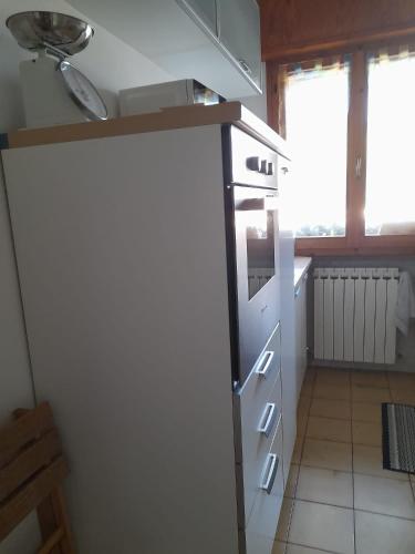 a kitchen with a white refrigerator and a window at Casa La Stazione in Cesenatico