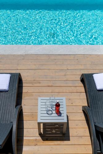 a table and chairs on a wooden deck next to a pool at Aelia Villa in Finikas
