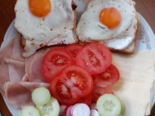a plate of eggs and tomatoes on toast at Apartman Petra in Senj