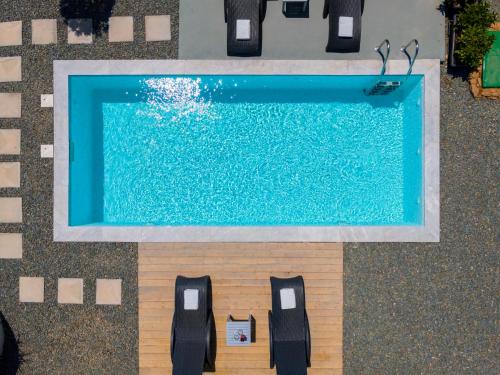 an overhead view of a swimming pool with black chairs at Aelia Villa in Finikas