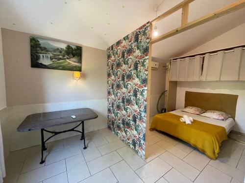 a small bedroom with a bed and a table at Bungalow Les Coraux in La Saline les Bains