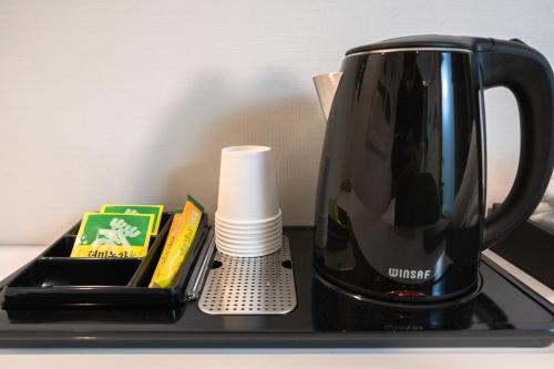 a black coffee pot sitting on top of a table at Hotel Centro Stay in Incheon