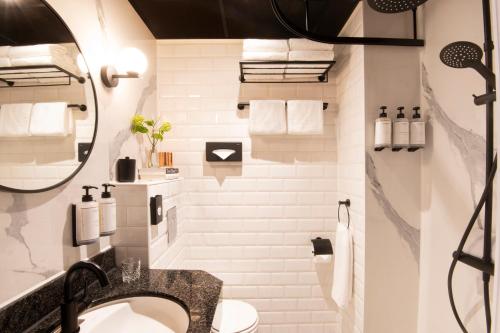 a white bathroom with a sink and a shower at Jan Luyken Amsterdam in Amsterdam