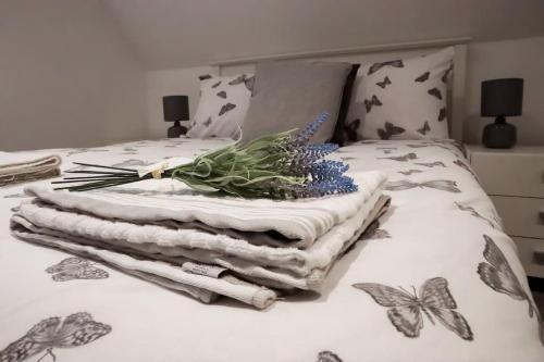 a bed with a pile of towels and butterflies on it at Aviary Lodge in Hurn