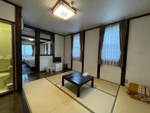 a living room with a table and a bed at Hotel Sejour Mint in Hakuba in Hakuba