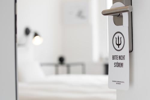 a door latch with a sign on it in a room at Das Kubatzki in Sankt Peter-Ording