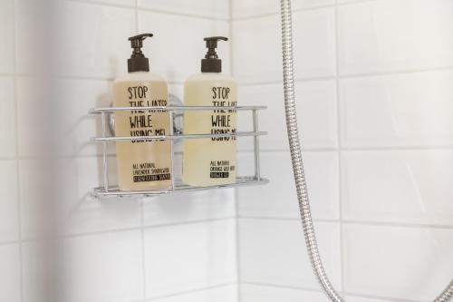 three soap bottles on a shelf in a bathroom at Das Kubatzki in Sankt Peter-Ording