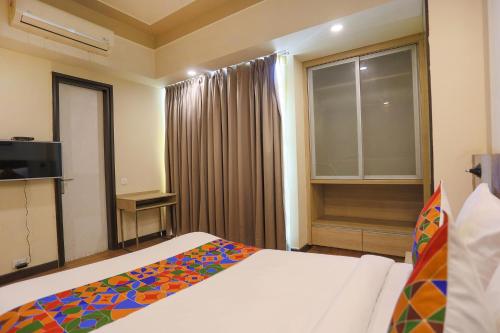 a bedroom with a bed and a large window at FabHotel Sapphire 83, Manesar, Gurgaon in Gurgaon