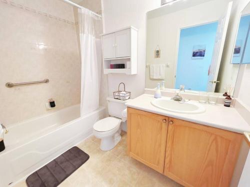ein Badezimmer mit einem Waschbecken, einem WC und einer Badewanne in der Unterkunft Barrie Ocean Kingdom in Barrie
