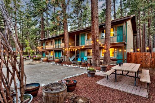 uma casa na floresta com uma mesa de piquenique em frente em The Alder Inn em South Lake Tahoe