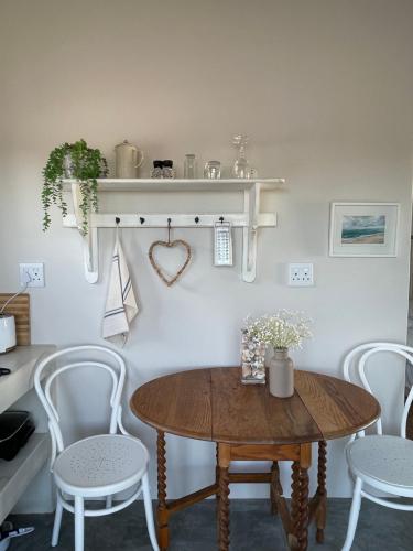 a dining room with a wooden table and chairs at Bougain Villa Studio 2 in Paternoster