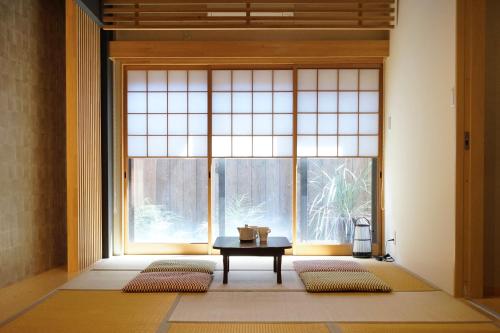 a room with a table in front of a large window at 継TSUNAGU 空蝉Utsusemi帚木Hahakigi in Kyoto