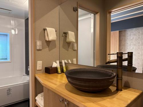 a bathroom with a large bowl sink on a counter at 継TSUNAGU 空蝉Utsusemi帚木Hahakigi in Kyoto