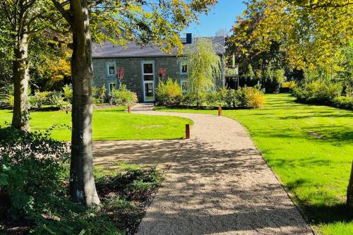a walkway in front of a house with trees and grass at Jacuzzi - BBq - Jardin - Garden Lodge - Le Tulipier in Olne