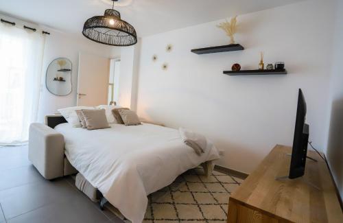 - une chambre blanche avec un lit blanc et une télévision dans l'établissement Gambetta calme et confort avec balcon a Annecy, à Annecy