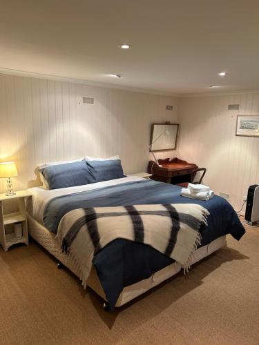 1 dormitorio con 1 cama grande y 1 mesa en Lumeah - Servant Quarters, en Hobart