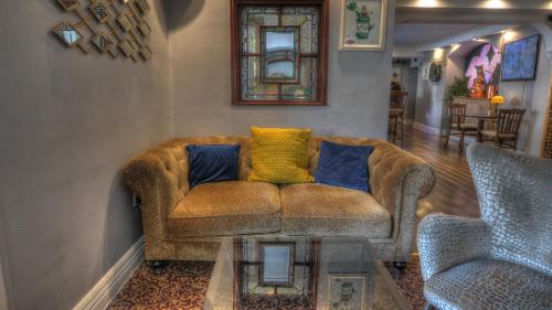 a living room with a couch and a glass table at Dunster Castle Hotel in Dunster
