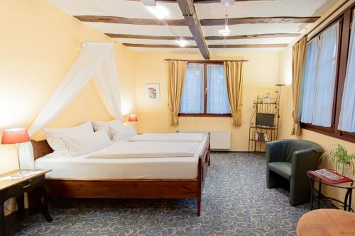 ein Hotelzimmer mit einem Bett und einem Stuhl in der Unterkunft Hotel Weinhaus Weiler in Oberwesel