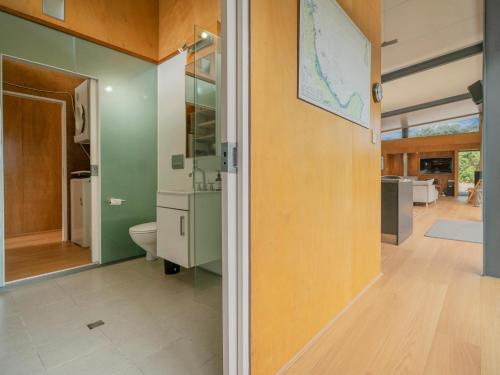 a bathroom with a toilet and a wall with a map on it at Little Paua - Pauanui Holiday Home in Pauanui