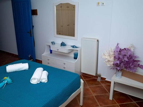 a bedroom with a blue bed with a sink and a mirror at Meli Apartments near sea side in Kythira