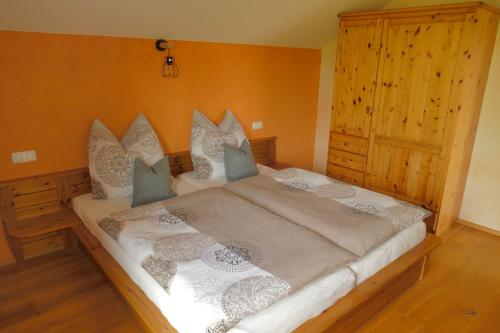 a bedroom with a large bed and a wooden cabinet at Ferienwohnung Abendsonne in Oy-Mittelberg