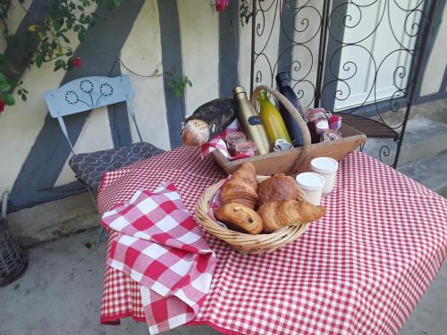 a basket of bread and pastries on a table at Un week-end à la campagne in Pont-Audemer